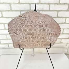Decorative memorial plaque on a black stand with engraved text