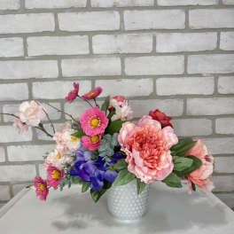 Mixed bouquet in a white textured vase with pink, purple, and white flowers