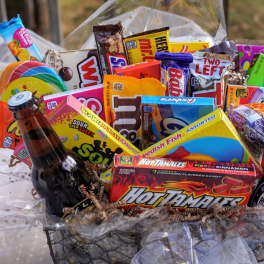 Gift basket filled with candy boxes and two soda bottles