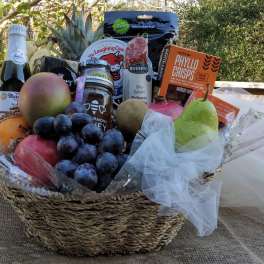 Gift basket with fruit, grapes, cheese, salami, and crackers