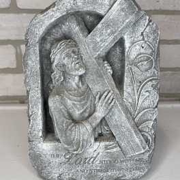 Stone religious plaque of Jesus carrying a cross