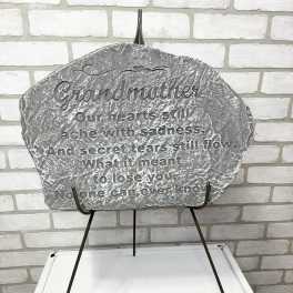 Gray memorial plaque on a metal stand with engraved text