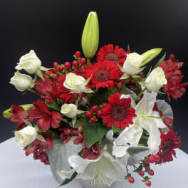 Red gerberas and white roses in a white vase