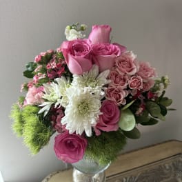Pink roses and white chrysanthemums arranged in a glass vase