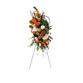 Tall floral standing spray with orange and white roses on an easel