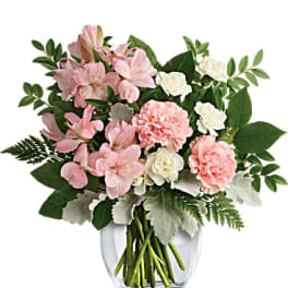 Pink and white flowers arranged in a clear glass vase