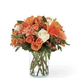 Orange and white mixed bouquet in a clear glass vase