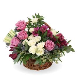 Basket arrangement of pink and white roses with purple flowers