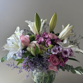 Pink and white bouquet with lilies and roses in a glass vase