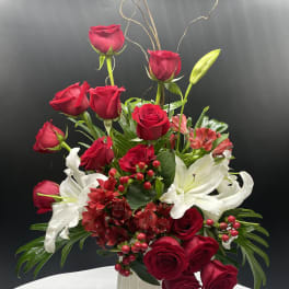 Red roses and white lilies arranged in a white vase