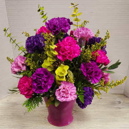 Pink and purple carnations arranged in a magenta vase