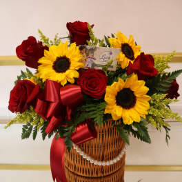 Red roses and yellow sunflowers in a wicker basket with a red ribbon