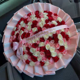 Round bouquet of red, pink, and white roses with a birthday ribbon
