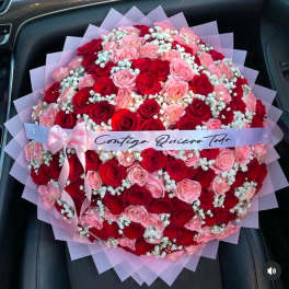 Large bouquet of red and pink roses with baby's breath and a ribbon