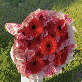 Bouquet of red gerbera daisies and pink roses with gingham bows