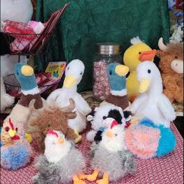Plush duck and bird toys arranged around a small gift display