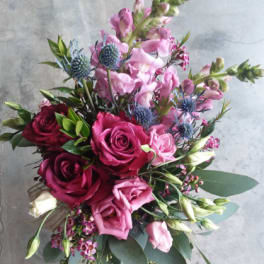Bouquet of pink and burgundy roses with blue thistle-like flowers