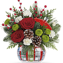 Holiday bouquet with red roses, white blooms, and pinecones in a decorated glass vase