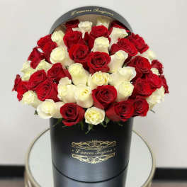 Red and white roses arranged in a black round box