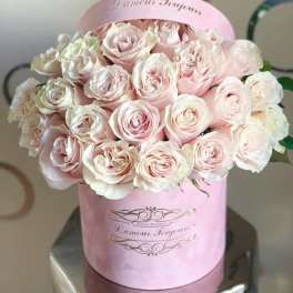 Pink roses arranged in a round pink hat box
