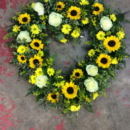 Heart-shaped floral wreath with yellow sunflowers and white roses