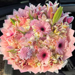 Pink mixed bouquet with gerbera daisies and lilies wrapped in pastel paper