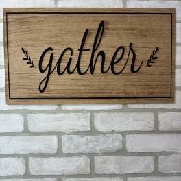 Wooden wall sign with the word "gather" in black script