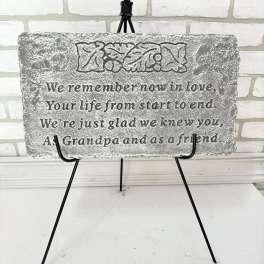 Gray memorial plaque on a black easel with engraved text