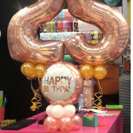 Rose-gold number 25 balloons with a Happy Birthday balloon and small gold balloons.