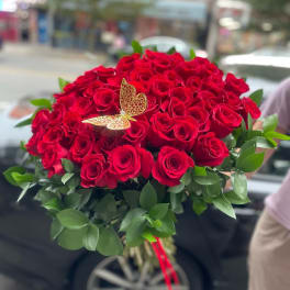 Large bouquet of red roses with a gold butterfly decoration