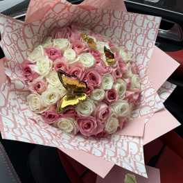 Pink and white rose bouquet wrapped in patterned pink paper with butterfly picks