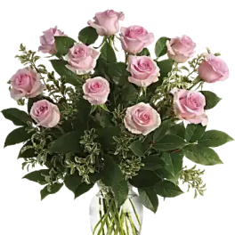 Arrangement of light pink roses in a clear glass vase with visible stems
