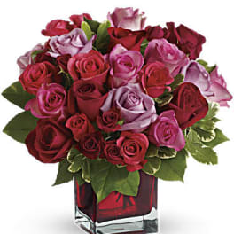 Bouquet of red and pink roses in a square glass vase