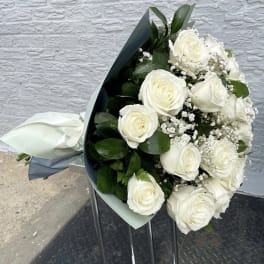 Bouquet of white roses with baby's breath and dark green foliage