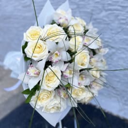 Bouquet of white roses and white orchids with long grass accents