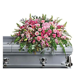 Pink floral casket spray on a silver casket
