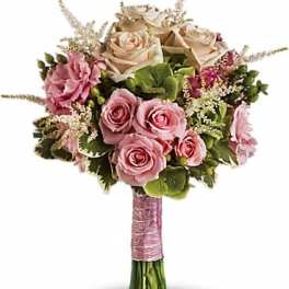 Bouquet of pink and cream roses with green accents and a pink wrapped handle