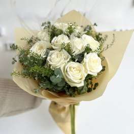 Bouquet of white roses wrapped in tan paper