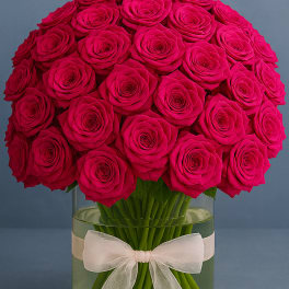 Bouquet of hot pink roses in a glass vase with a white ribbon
