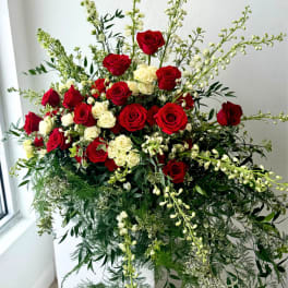 Large red and white rose arrangement with cascading greenery