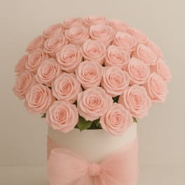 Bouquet of pale pink roses in a white hat box with a pink bow