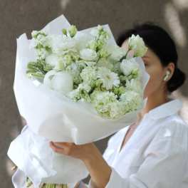 White bouquet with mixed blooms wrapped in white paper