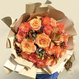 Large bouquet of orange roses wrapped in tan paper