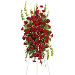 Tall standing spray of red roses on a white easel