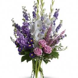Purple and pink bouquet with white flowers in a clear glass vase