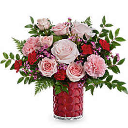 Pink roses and carnations in a red glass vase