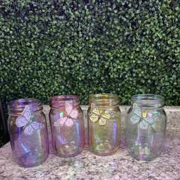 Four iridescent glass jars with butterfly decorations