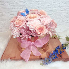 Pink rose and chrysanthemum arrangement in a round box with a pink bow