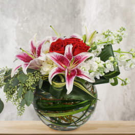 Bouquet of red roses and pink lilies in a glass vase