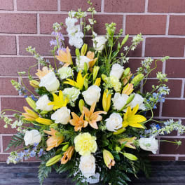 Large mixed floral arrangement with white roses and yellow lilies